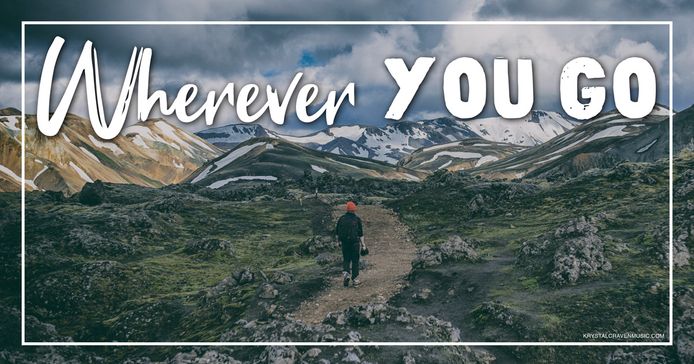 The title text "Wherever You Go" in a large white font appearing above a mountain trail with a hiker walking up the trail away from the camera.