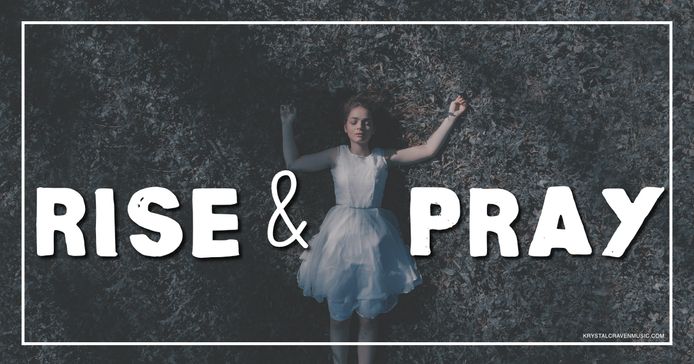 A woman in a white dress lying in a dark grassy area with arms sprawled outward with the words "Rise & Pray" overlaying the image.