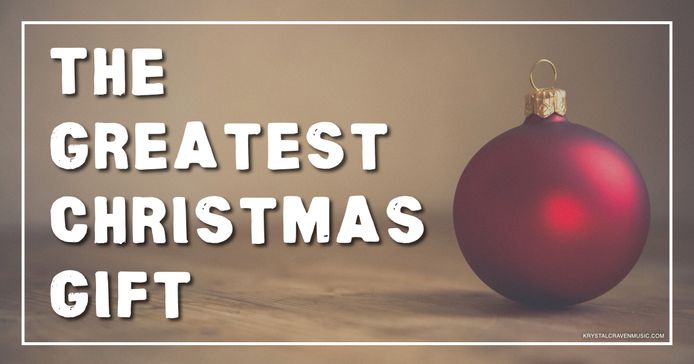 A satin red ball ornament. Overlaying the image are the words "The Greatest Christmas Gift".
