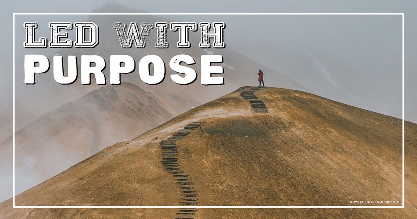 Devotional title text overlaying a mountain with brown dead ground cover and a pathway up it. There's a person standing at the top of the pathway and fog in the background through which you can barely see the mountains behind it.