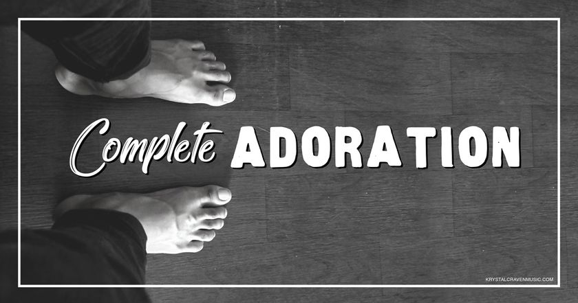 Devotional title text of "Complete Adoration" overlaying a black and white picture of bare feet standing on wood floor.