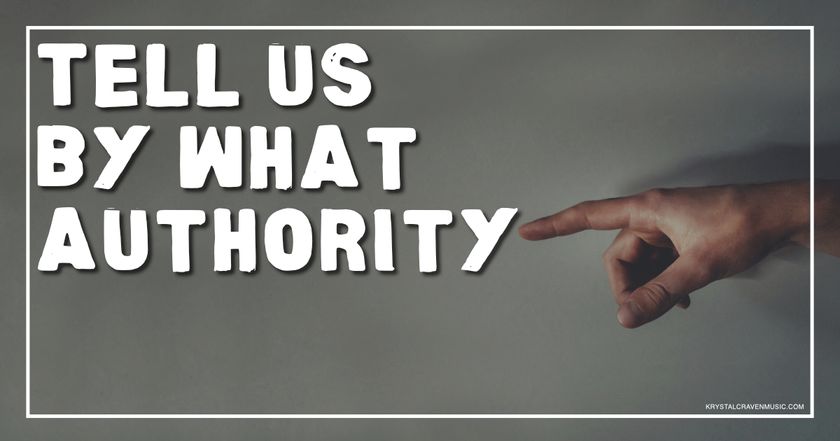 A person's hand pointing to the words "Tell Us By What Authority" written in bold, white lettering against a gray background. The hand is positioned on the right side of the image, emphasizing the importance of the message.