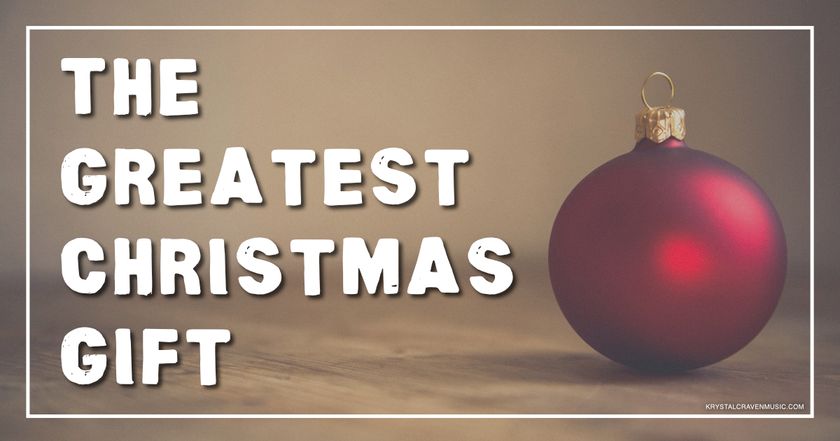 A satin red ball ornament. Overlaying the image are the words "The Greatest Christmas Gift".